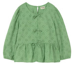 The Cozmo Girls' Alma Eyelet Blouse features a light green hue, long sleeves with delicate Swiss embroidery and eyelet details, three front bows, a round neckline, softly puffed sleeves, and a peplum hem.