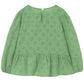 The Cozmo Girls' Alma Eyelet Blouse features a green color, long sleeves with puffed shoulders, an eyelet floral pattern, round neckline, back button closure, and a gathered peplum hem.
