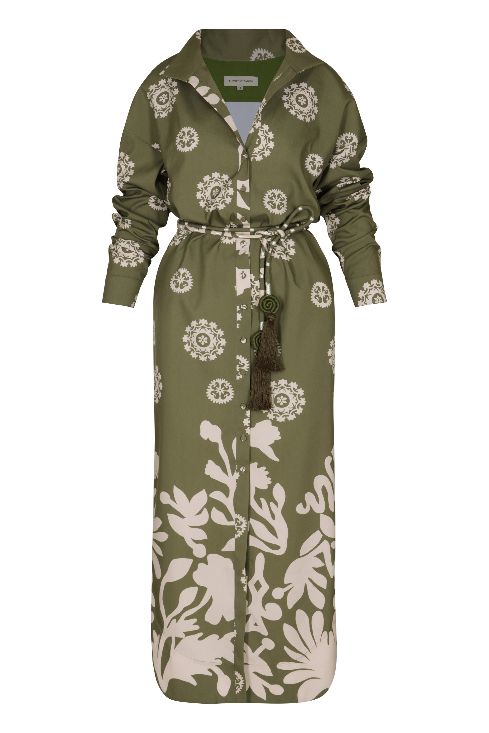 A full-length Andres Otalora Armenia Dress in green and white print with long sleeves, featuring a button-up front, a belted waist, and made from 100% cotton.