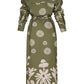 A long-sleeved, olive green and white print Andres Otalora Armenia Dress with floral patterns, buttoned cuffs, a waistband, and a collar, displayed from the back.