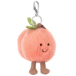 The Jellycat Amuseables Peach Bag Charm features a smiling face, green leaf accents, and brown legs on a plush peach, attached to a metal keyring and clip—perfect for adding cute charm to any bag.