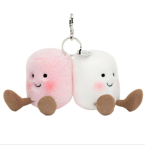 The Jellycat Amuseables Pair of Marshmallows Bag Charm features two kawaii plush keychains—one pink, one white—with smiling faces, brown feet, and metal keyrings for a cute accessory on any bag or keys.