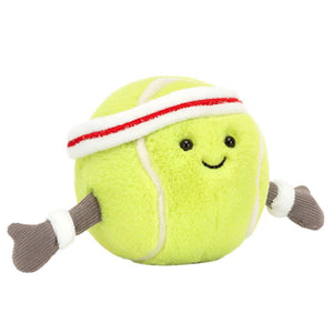 The Jellycat Amuseable Sports Tennis Ball is a plush toy with a smiling face, white headband with red stripe, wristbands, and soft fabric arms.