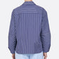 Person wearing the Aura Top by Callas Milano, a blue and white Italian stripe poplin long-sleeve shirt featuring horizontal stripes on the upper back and forearms, shown from the back.