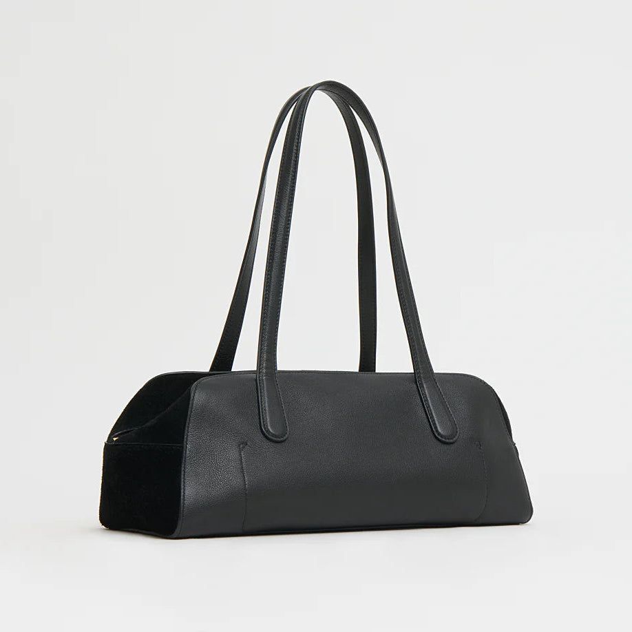 The Mansur Gavriel Helios Bag, a black rectangular handbag with long double shoulder straps and a minimalist smooth leather design, is shown against a plain white background.