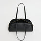 A black leather Mansur Gavriel Helios Bag with dual shoulder straps and a gold zipper, shown against a plain white background.