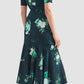 A woman is seen from the back wearing the Erdem Short Sleeve Abstract Rose Top, paired with black textured flat shoes, standing against a plain light background.