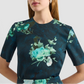 A woman wears the Erdem Short Sleeve Abstract Rose Top, featuring a modern rose pattern, against a plain background.