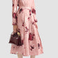 A woman stands gracefully in the Erdem Pleated Abstract Rose Skirt, her look blending feminine charm with stylish elegance.