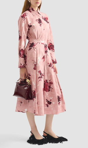A woman stands gracefully in the Erdem Pleated Abstract Rose Skirt, her look blending feminine charm with stylish elegance.