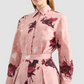 A woman wearing Erdem’s Long Sleeve Abstract Rose Shirt, a pink cotton poplin dress with red floral print, is shown from shoulders to waist.