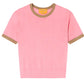 The Guest in Residence Airy Ringer Tee, a light pink short-sleeve lightweight cashmere sweater with brown trim on the collar and sleeve cuffs, is laid flat on a white background.