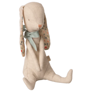 The Maileg Bunny Albin, by Maileg, is crafted from soft linen quality and features floral-patterned ears, a green fabric neck bow, and simple stitched facial features. This charming rabbit doll sits upright and has magnets in its hands for added versatility.