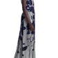 A person in an Altuzarra Pamela dress, a sleeveless pleated midi with a blue and gray abstract pattern similar to a sycamore ladybug print, paired with black heels.