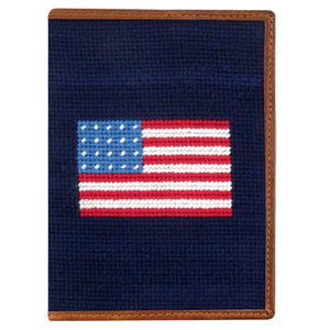 The Smathers & Branson American Flag Passport Case features a small rectangular needlepoint design with an American flag on a dark blue background and fine Italian leather trim—ideal as a travel organizer.