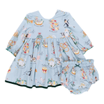 The Pink Chicken Baby Girl Amma Dress showcases a light blue children's dress embellished with festive illustrations such as animals and musical instruments, reminiscent of the "12 Days of Christmas." It includes matching bloomers, making it ideal for your little one's holiday celebrations.