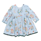 The Pink Chicken Girls Amma Dress is an enchanting light blue long-sleeve outfit, decorated with charming holiday-themed prints inspired by the 12 Days of Christmas, showcasing wreaths, birds, and musical instruments.