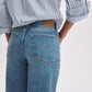 Model wearing Rag & Bone Flexi Andi Full Wide high-waisted, wide-leg light blue denim jeans, paired with a blue and white striped shirt. Shown from the waist down with hands in back pockets.
