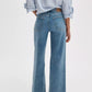 Person wearing a blue and white striped shirt and Rag & Bone Flexi Andi Full Wide high-waisted denim jeans, shown from the back against a plain background.
