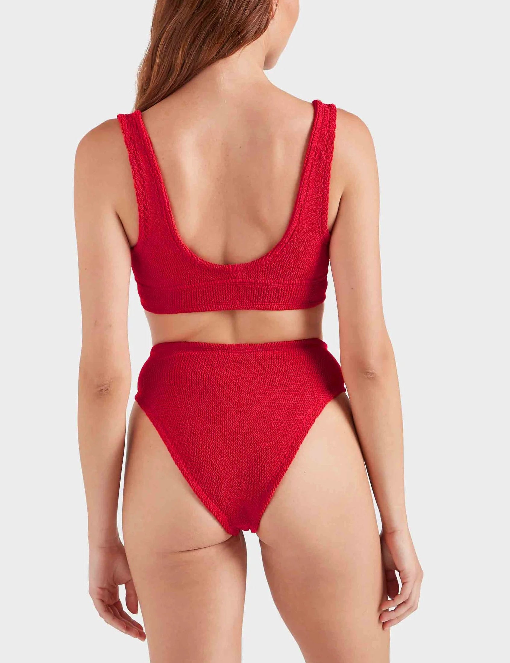 A woman wears the Hunza G Angel Bikini in red, shown from the back against a plain light background. This supportive, one-size swimwear offers comfort and style for various body types.