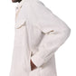 A person stands in side profile with a hand in their pocket, wearing the Rag & Bone Angus Linen Shirt Jacket—an off-white, long-sleeve collared style with a chest pocket made from lightweight linen.