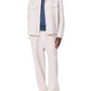 A man wearing the Angus Linen Shirt Jacket by Rag & Bone with matching pants, a blue t-shirt, and beige sneakers stands against a white background.