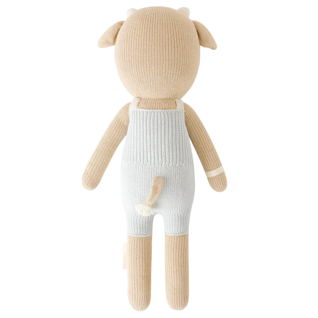 Asher the Cow - Regular 20" by Cuddle + Kind: a tan knit stuffed animal in white overalls, shown from the back with a tail and small horns—born on May 20th to inspire daily kindness.