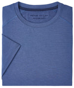 Folded blue Peter Millar Aurora Performance T-Shirt with visible "PETER MILLAR" branding, size 'M' label, and lightweight design for comfort.