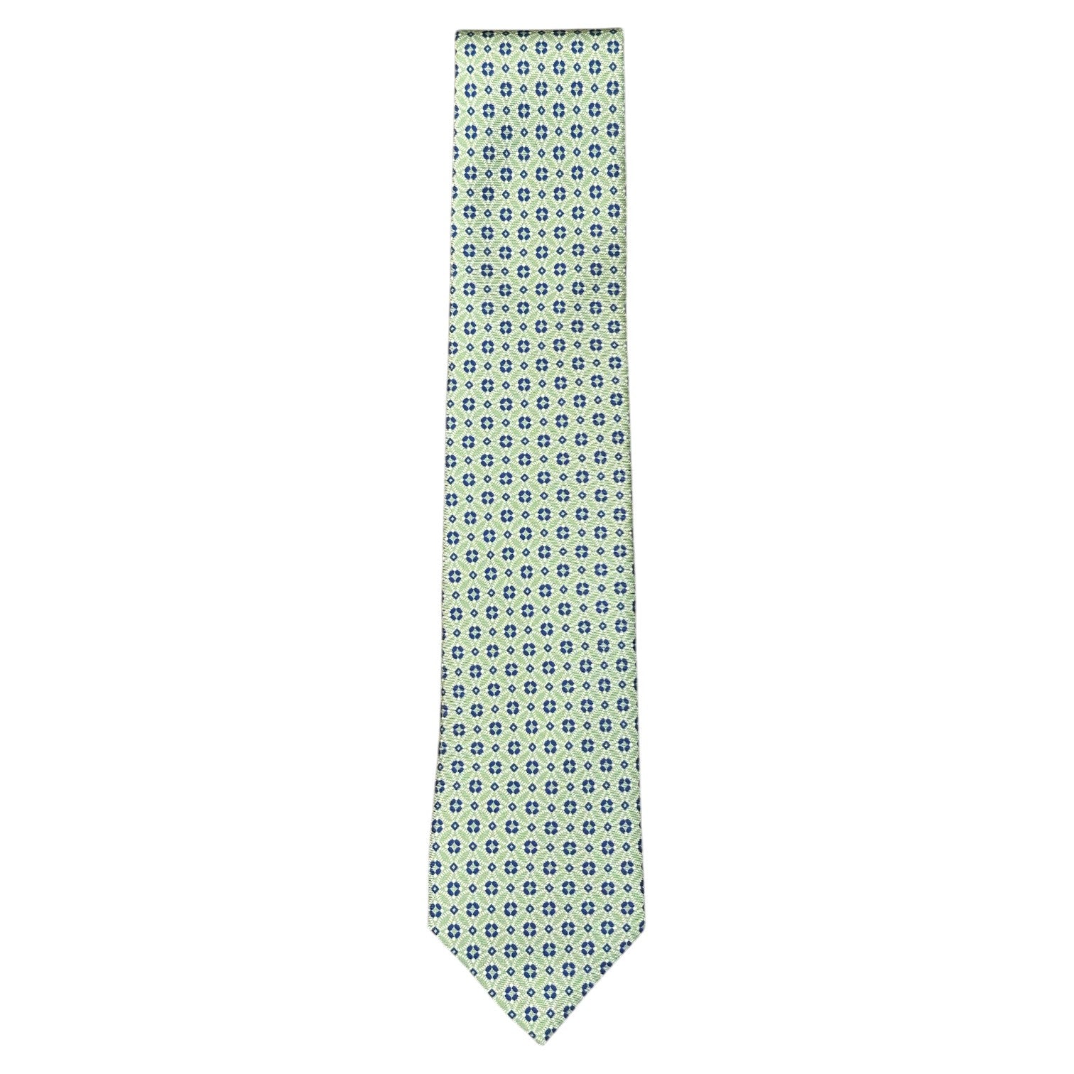 The Atomic Diamond Tie by Robert Jensen is a light green silk tie with a repeating pattern of small blue and white geometric shapes.