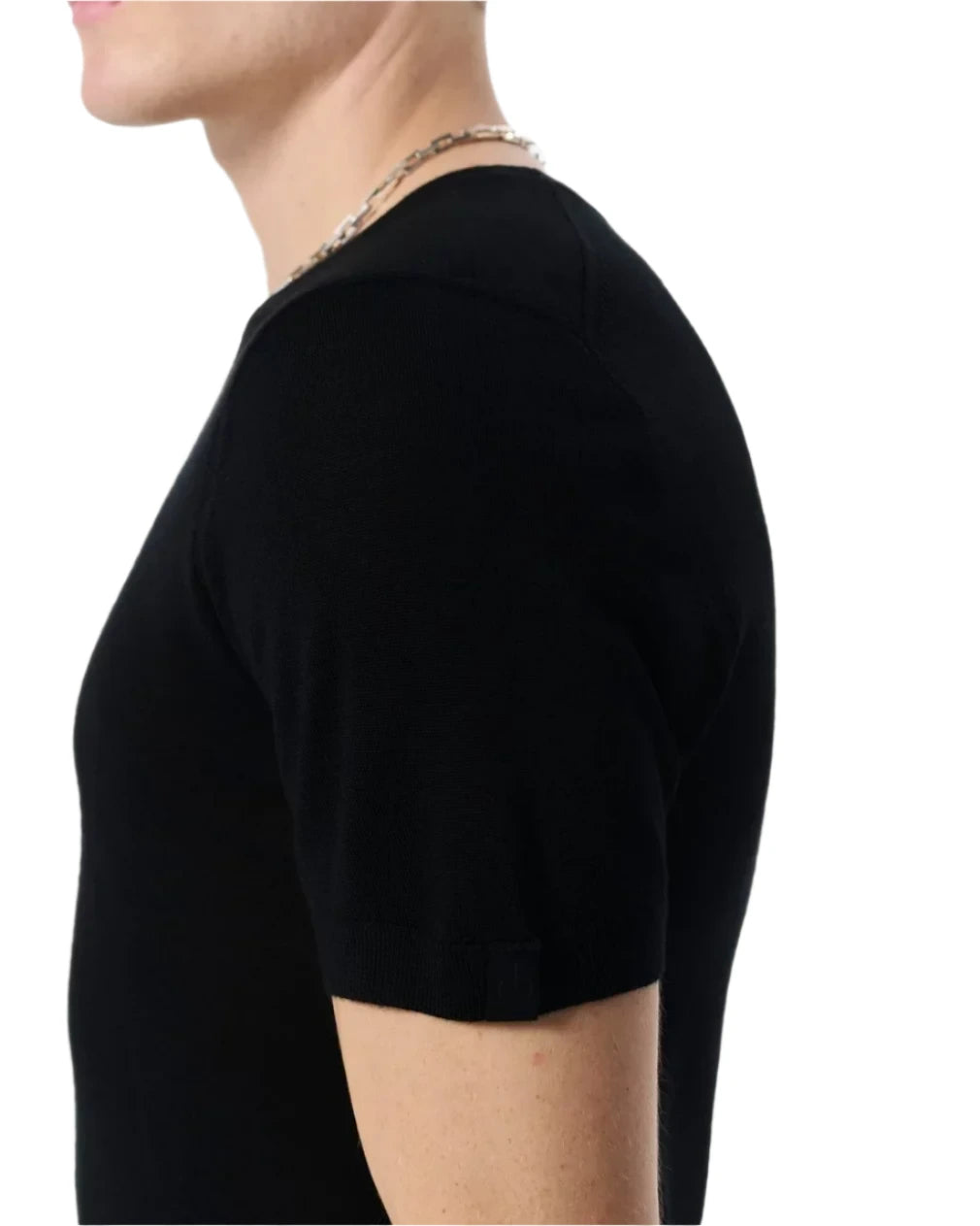 A person is shown from the side against a plain light background, wearing the black Aulton Knit Tee by Rag & Bone and a silver chain necklace.