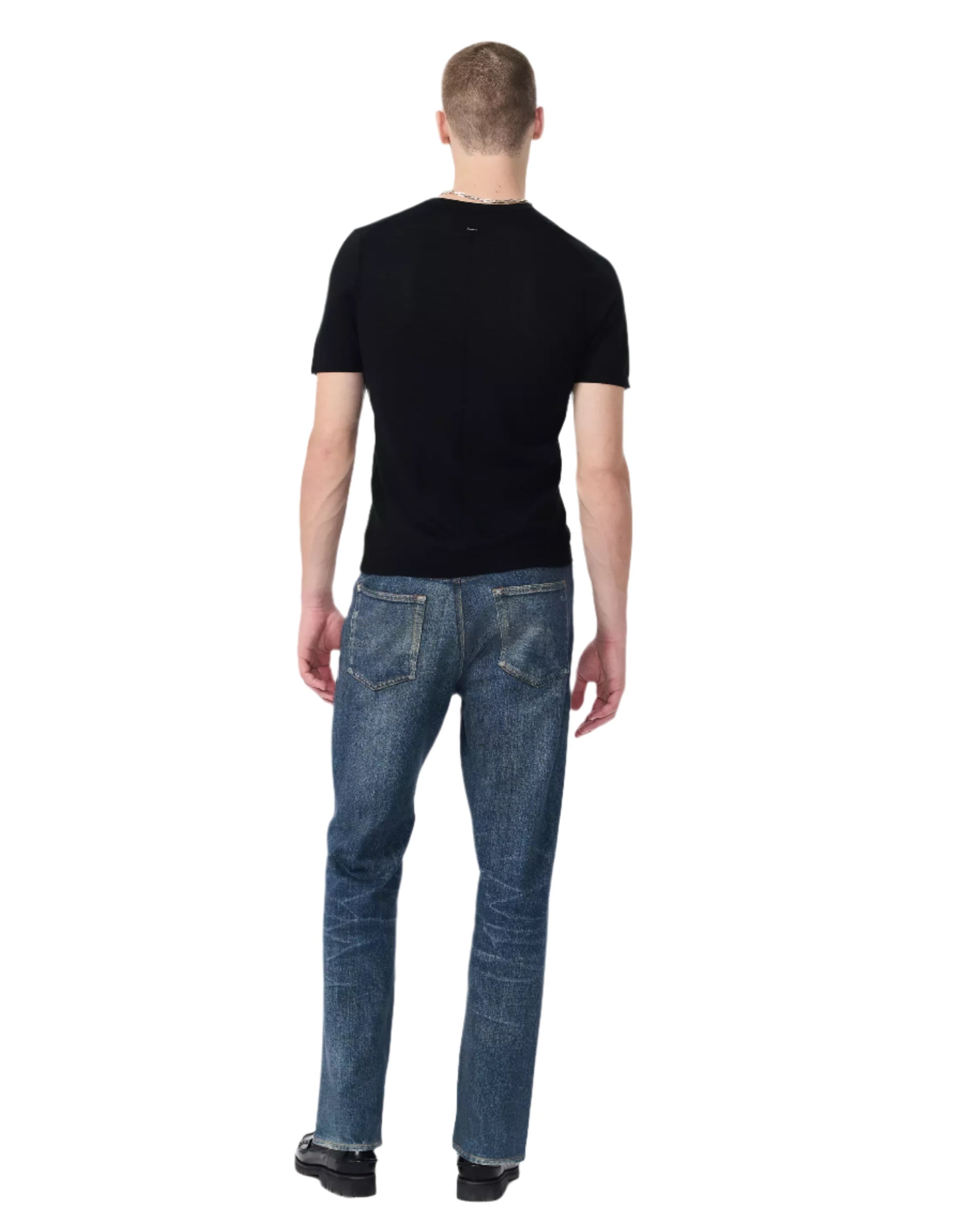 A person faces away against a plain light background, wearing the Rag & Bone Aulton Knit Tee in black with blue jeans.