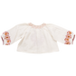 A white long-sleeve, loose-fitting Pink Chicken Girls' Ava Top by Pink Chicken, featuring colorful embroidered patterns on the chest and cuffs, perfect for Boho Fashion enthusiasts.