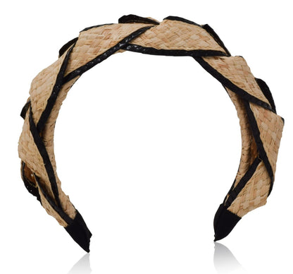 The Gigi Burris Ava Band is a handcrafted raffia straw headband accented with black trim, showcasing a twisted design that highlights Gigi Burris's exquisite millinery craftsmanship.