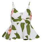 The Avenue Top by Cara Cara is a white sleeveless fitted peplum top featuring adjustable thin straps, a V-neckline, and a green leaf and pink flower print.