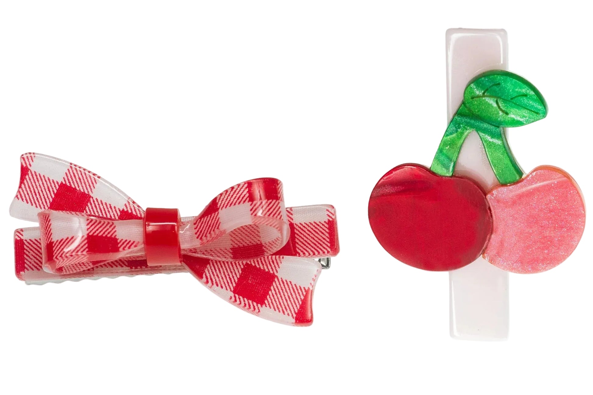 Add charm to any hairstyle with Lillies & Roses' Cherry & Red Checkered Bow Hair Clips: one showcases a red and white checkered bow, the other features a cherry and green leaf on a white base.