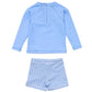 The Snapper Rock Baby Boys' Swaside Blue LS Let features a light blue long sleeve rash top with a back zipper and blue-white gingham swim shorts with an elastic waistband—a stylish, comfortable swim set.