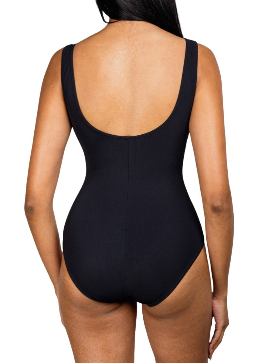 Rear view of a person in the Karla Colletto Basics Square Neck One Piece swimsuit, elegantly styled for a coastal getaway, against a white background.