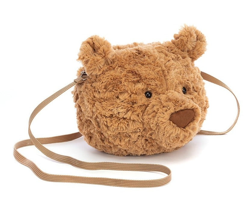The Jellycat Bartholomew Bear Bag is a plush, round, brown cross-body bag shaped like a teddy bear’s head, featuring cute ears and a long strap.