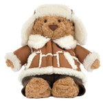 Jellycat Bartholomew Bear ‘Alpine’ wearing a shearling-lined aviator hat and matching coat with brown trousers.