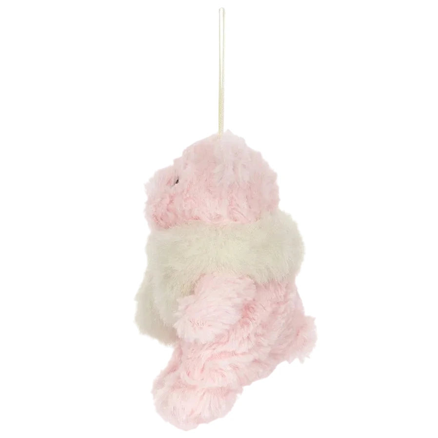 A light pink Jellycat Leola Bear Winter Warmer Decoration with a cream-colored scarf, hanging from a gold cord.