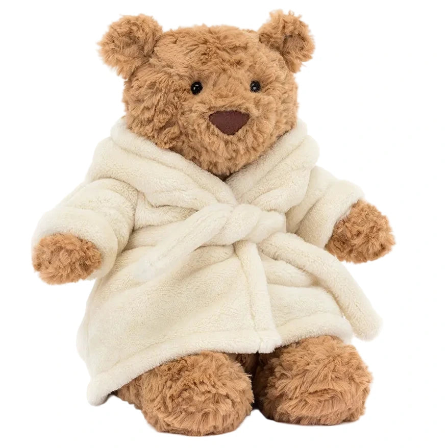 A Jellycat Bartholomew Bear Bathrobe plush, featuring a brown bear in a soft white robe, sits upright against a plain background.