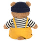 The Jellycat Bartholomew Bear Seafarer Outfit features a plush teddy bear facing away, dressed in a navy knit hat, striped shirt, and yellow strapped overalls—perfectly ready for a boat trip adventure.