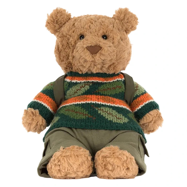The Jellycat Bartholomew Bear Hiking Outfit features Bartholomew Bear dressed in a green, orange, and brown striped sweater with khaki shorts, sitting upright and ready for cuddles.