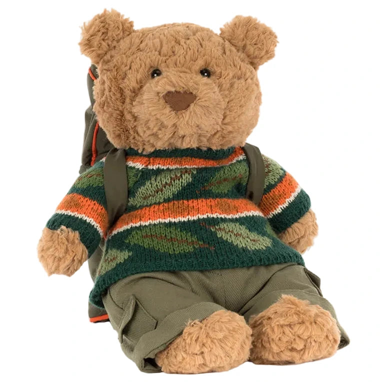The Jellycat Bartholomew Bear wears the Hiking Outfit, featuring a green, orange, and brown striped sweater, olive green pants, and a matching backpack.