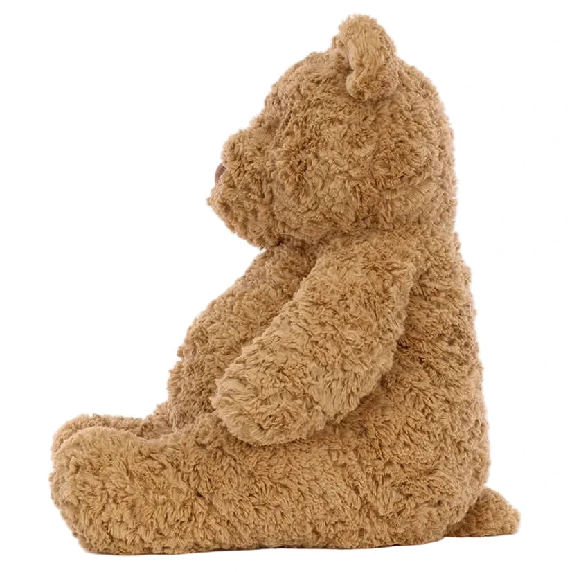 A Jellycat Bartholomew Bear Huge plush in brown is shown sitting upright in profile against a white background.