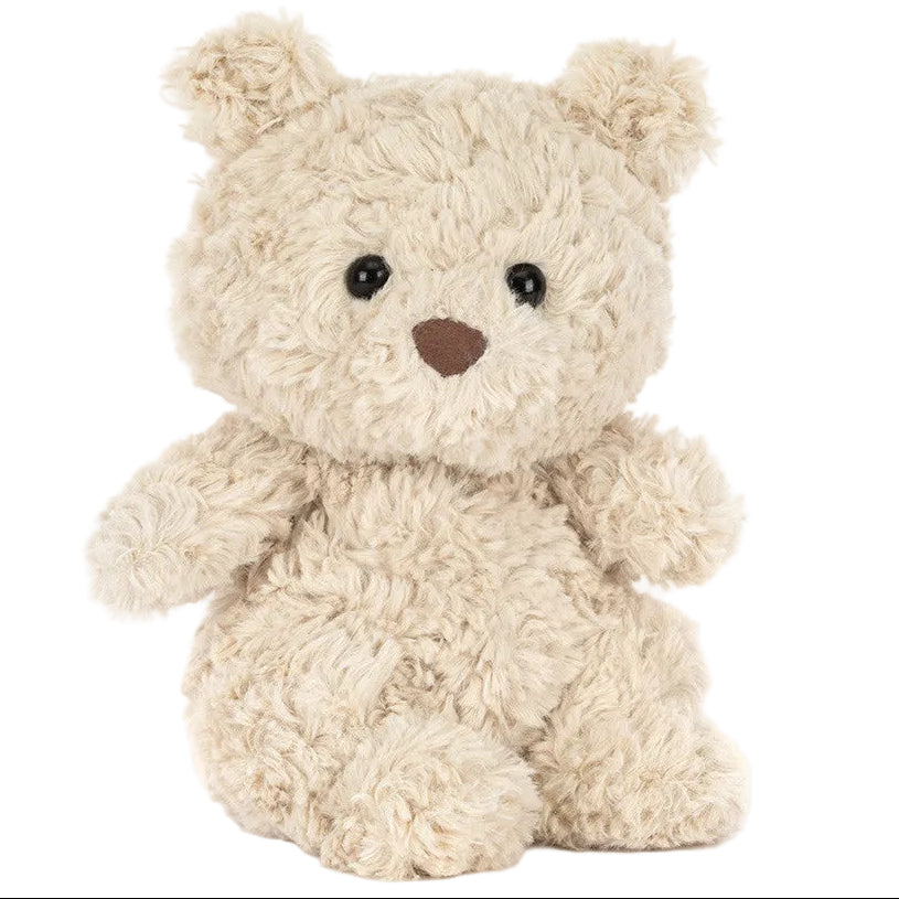A Bartholomew Bear Junior teddy bear from Jellycat, featuring beige fluffy fur, black eyes, and a brown nose, sits upright against a white background.