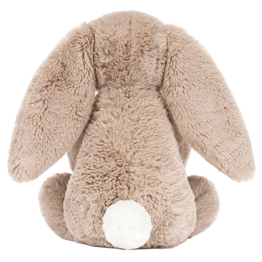 The Jellycat Bashful Beige Bunny 'Birthday' is pictured from the back, displaying long floppy ears and a white tail—a cute plush toy ideal for birthday gifting.