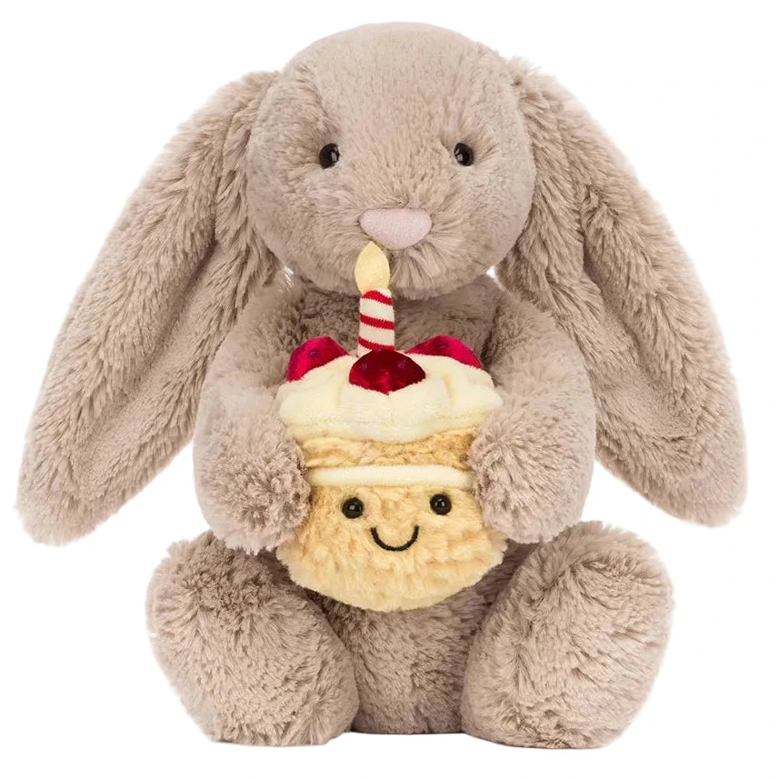 The Jellycat Bashful Beige Bunny 'Birthday' is an adorable plush toy holding a smiling cupcake with cherries and a striped straw—perfect as a birthday gift.