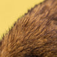 Close-up of the brown and black plush fur of the Jellycat Hoppleston Luxe Bunny Original, set against a yellow background, highlighting its signature softness.