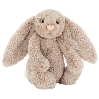 The Jellycat Bashful Bunny Beige Medium is a light brown plush toy with floppy ears, a pink nose, and soft fur. It sits upright against a white background—perfect for cuddling.